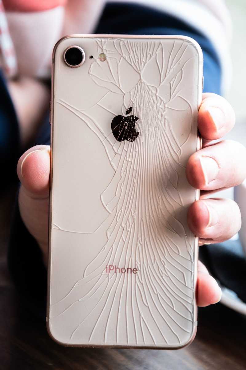 a person holding a broken iphone in their hand