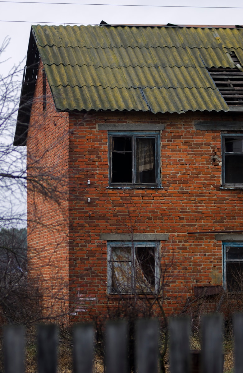 a red brick house with a green roof